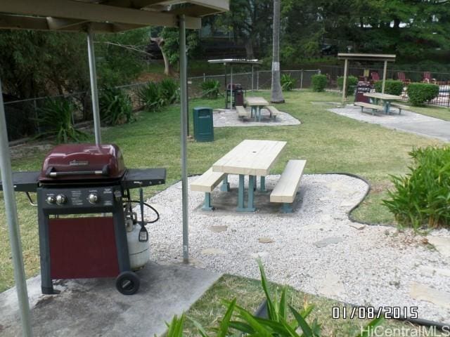 view of home's community featuring fence, a lawn, and a patio area