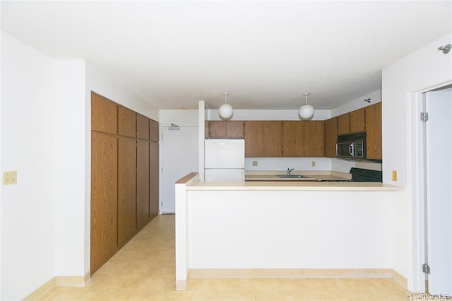 kitchen with freestanding refrigerator, black microwave, range with electric stovetop, brown cabinets, and a sink