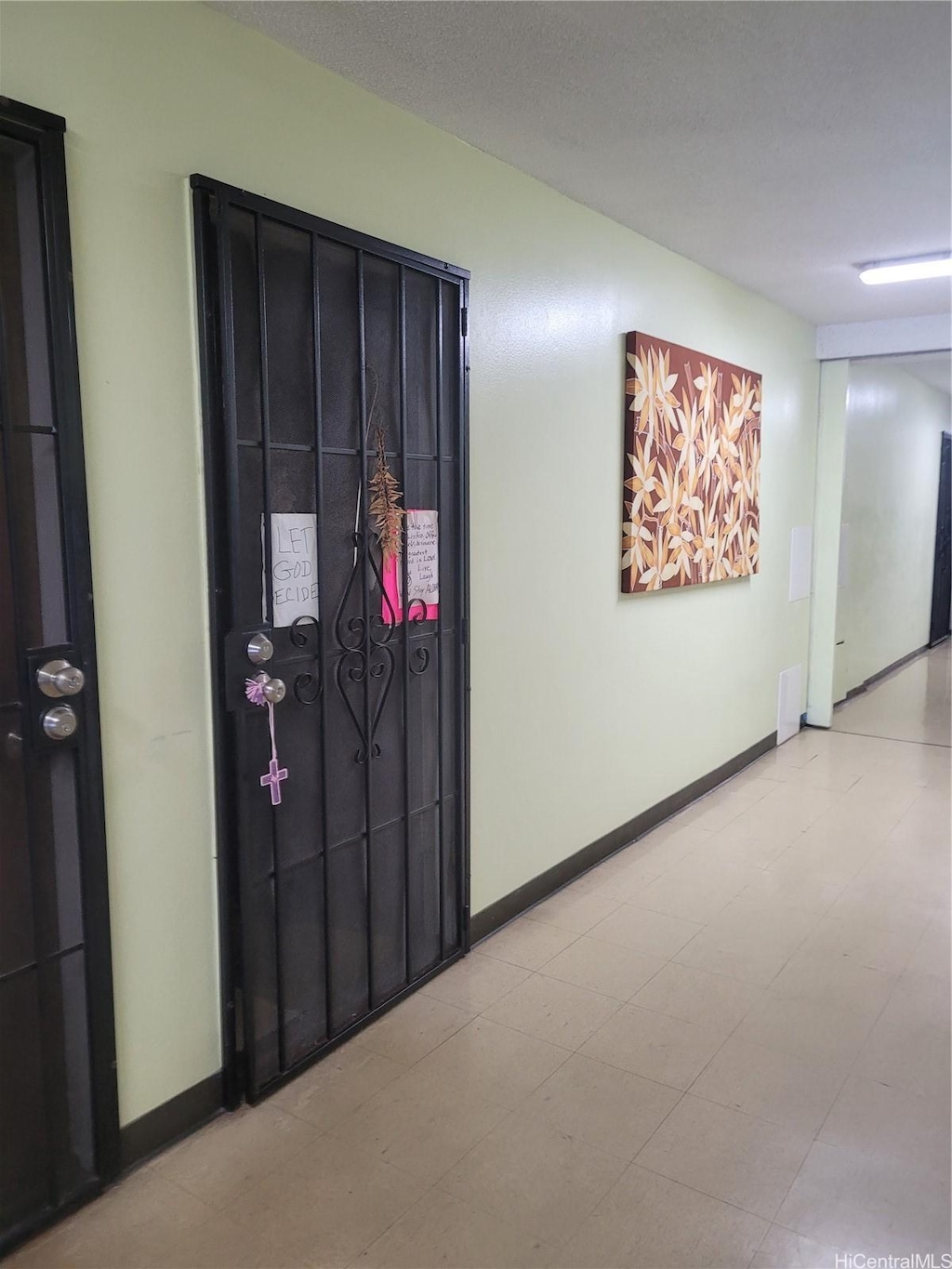 hall with baseboards and tile patterned floors