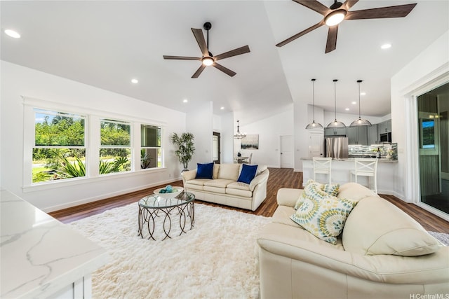 living area with ceiling fan, wood finished floors, and lofted ceiling
