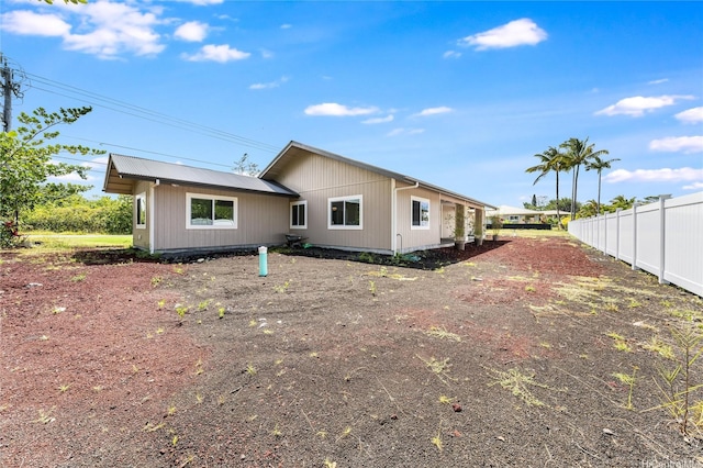 rear view of property featuring fence