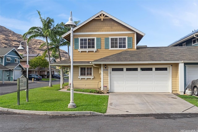 view of front of home with driveway, a shingled roof, a front yard, and a garage