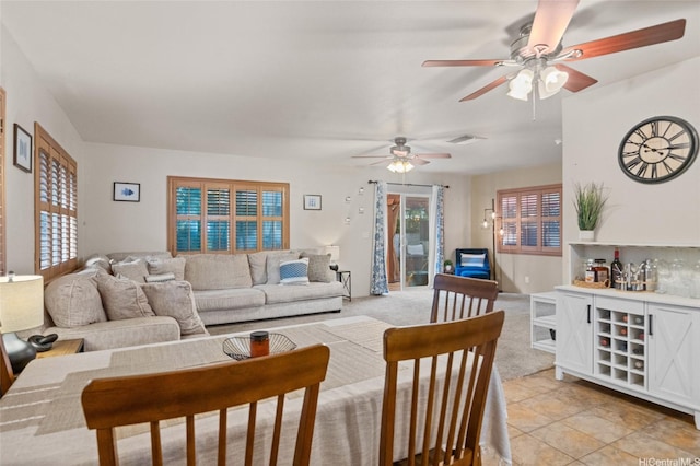 living area featuring visible vents and a ceiling fan