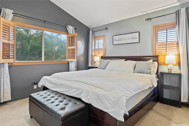 bedroom with vaulted ceiling, multiple windows, and carpet