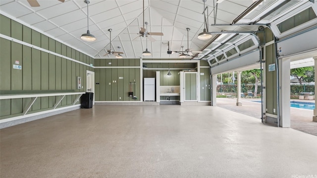 garage featuring freestanding refrigerator, a ceiling fan, and an outdoor pool