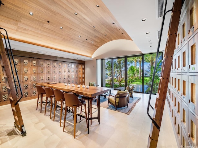 dining space featuring light floors, recessed lighting, vaulted ceiling, a wall of windows, and wood ceiling