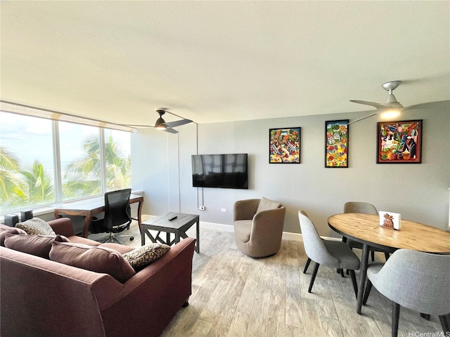 living room with baseboards, a ceiling fan, and wood finished floors