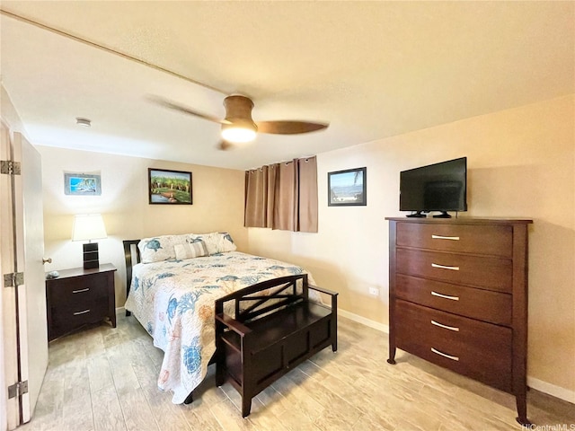 bedroom featuring baseboards, ceiling fan, and light wood-style floors