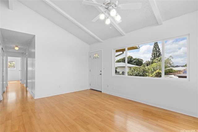 unfurnished room with a ceiling fan, a textured ceiling, beam ceiling, baseboards, and light wood finished floors