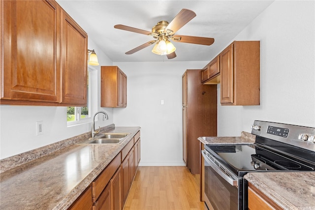 kitchen featuring a ceiling fan, a sink, light wood-type flooring, brown cabinets, and electric stove