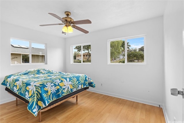bedroom with baseboards, ceiling fan, and wood finished floors