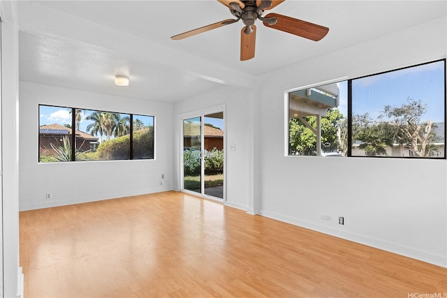 spare room with ceiling fan, wood finished floors, and a healthy amount of sunlight