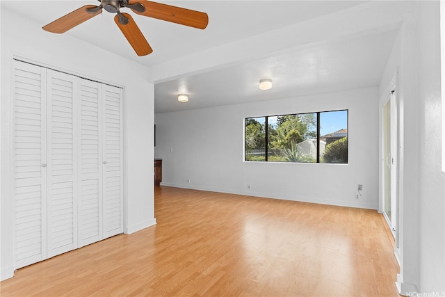 unfurnished bedroom with light wood-type flooring, baseboards, ceiling fan, and a closet
