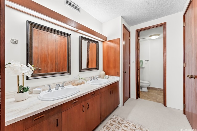 4340 Pahoa Ave Unit 19D, Honolulu, HI 96816 - bathroom featuring double vanity, toilet, and a textured ceiling