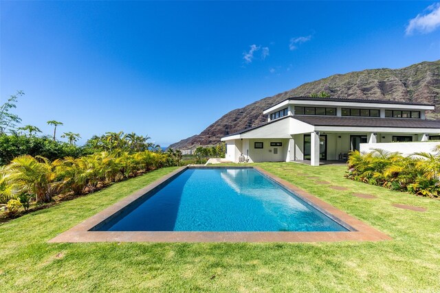 outdoor pool featuring a lawn and a mountain view