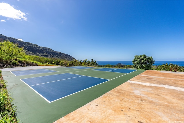 view of tennis court with community basketball court and a mountain view