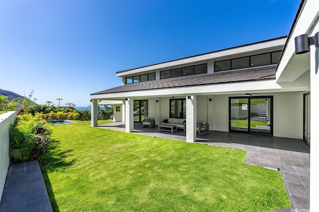 rear view of house featuring an outdoor hangout area, stucco siding, an outdoor pool, a patio, and a yard