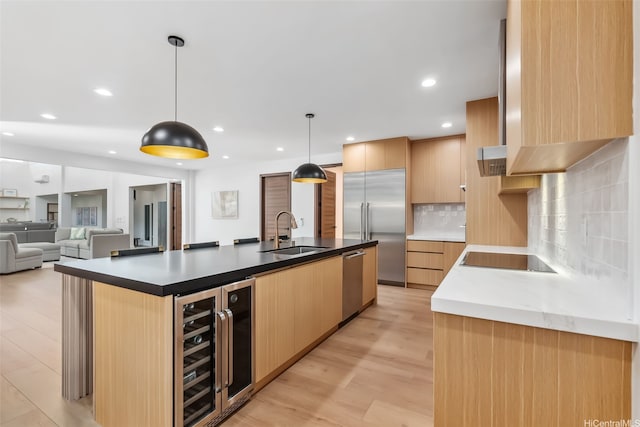 kitchen featuring wine cooler, appliances with stainless steel finishes, light brown cabinetry, and a sink