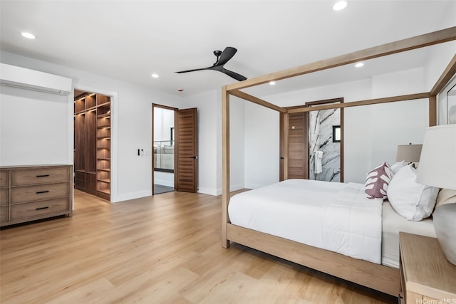 bedroom with recessed lighting, baseboards, an AC wall unit, and a spacious closet