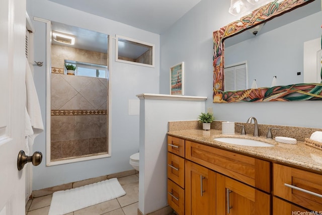 full bathroom with toilet, tile patterned floors, tiled shower, and vanity
