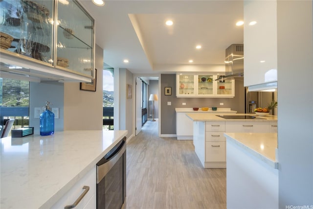 1022 Prospect St Unit 903E, Honolulu, HI 96822 - kitchen with island range hood, black electric stovetop, recessed lighting, light wood finished floors, and white cabinetry