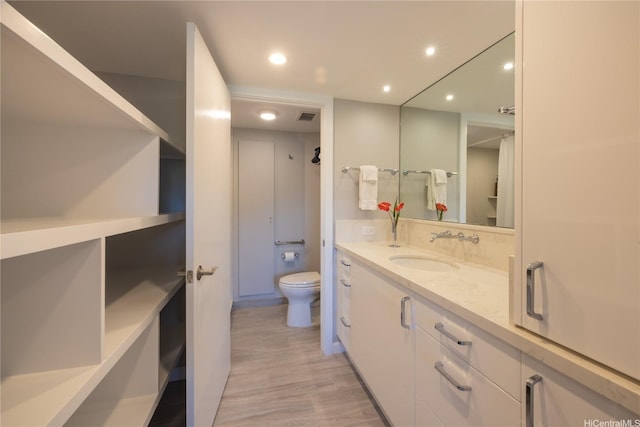 1022 Prospect St Unit 903E, Honolulu, HI 96822 - bathroom with toilet, wood finished floors, vanity, and recessed lighting