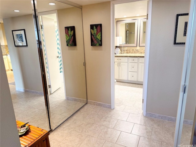 hall featuring baseboards, recessed lighting, and light tile patterned flooring