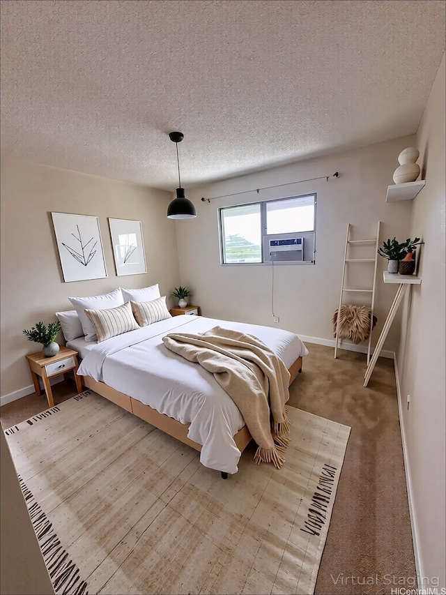 98-833 Noelani St Unit 155, Pearl City, HI 96782 - bedroom featuring a textured ceiling, cooling unit, baseboards, and light colored carpet