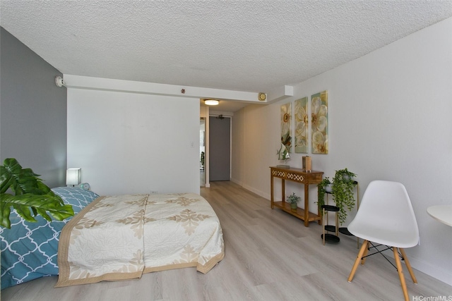 bedroom featuring light wood-type flooring and a textured ceiling