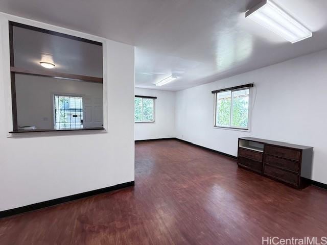 unfurnished room with baseboards and wood finished floors