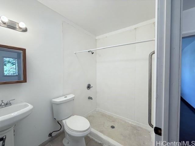 full bathroom featuring toilet, a shower stall, and a sink