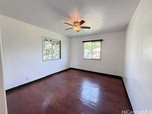 spare room with a ceiling fan, baseboards, and wood finished floors