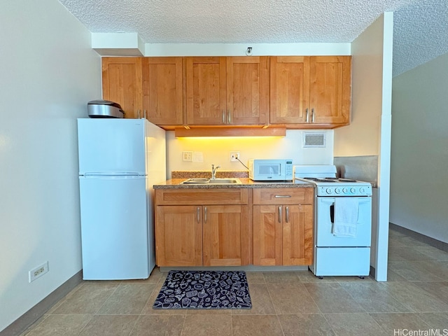 364 Seaside Ave Unit 1109, Honolulu, HI 96815 - kitchen with white appliances, a sink, a textured ceiling, brown cabinetry, and baseboards
