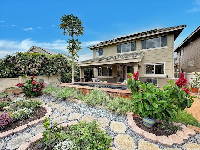 back of property featuring central air condition unit, fence, metal roof, and a wooden deck
