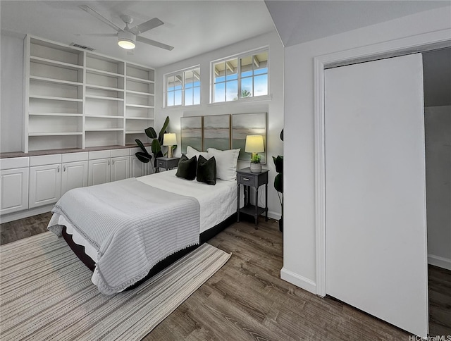 bedroom featuring baseboards, ceiling fan, dark wood finished floors, and visible vents