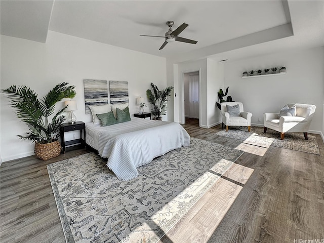 bedroom with baseboards, a ceiling fan, and wood finished floors