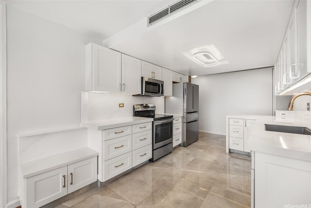 250 Kawaihae St Unit 18D, Honolulu, HI 96825 - kitchen with appliances with stainless steel finishes, a sink, white cabinets, and light countertops