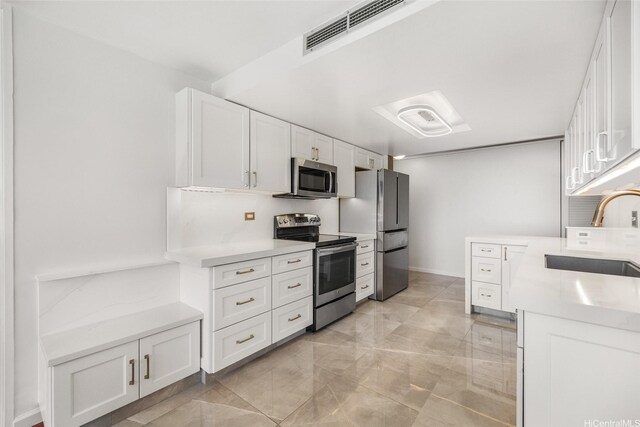 250 Kawaihae St Unit 18D, Honolulu, HI 96825 - kitchen featuring stainless steel appliances, white cabinets, light countertops, and light marble finish floors