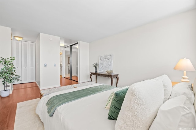 250 Kawaihae St Unit 18D, Honolulu, HI 96825 - bedroom featuring wood finished floors, two closets, and baseboards