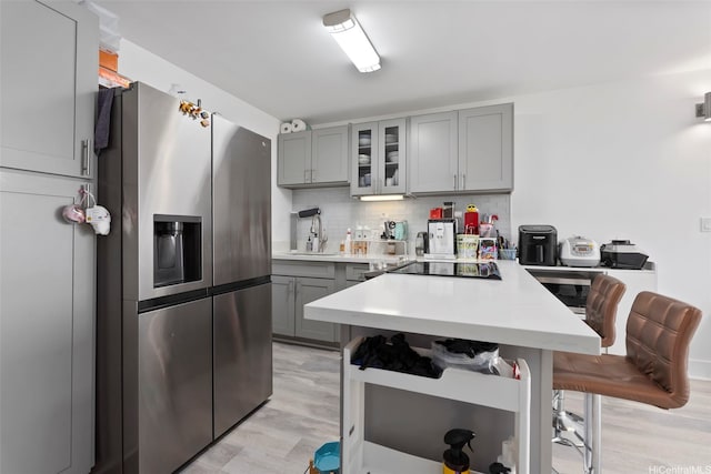 3045 Ala Napuaa Pl Unit 311, Honolulu, HI 96818 - kitchen with gray cabinetry, stainless steel refrigerator with ice dispenser, black electric stovetop, and light countertops