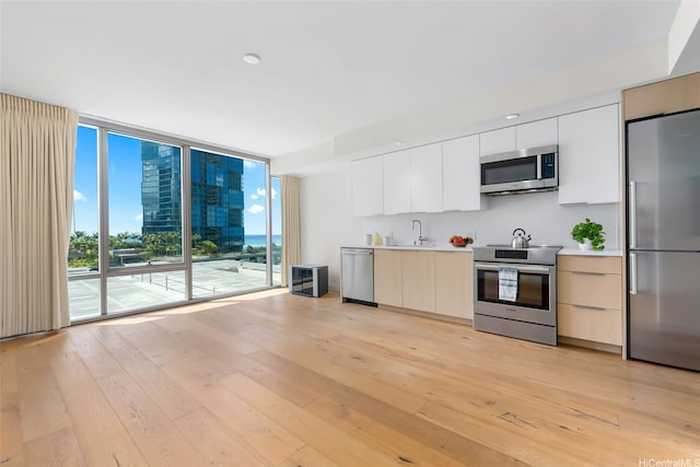 1001 Queen St Unit 1010, Honolulu, HI 96814 - kitchen featuring stainless steel appliances, modern cabinets, light wood-type flooring, light countertops, and tasteful backsplash