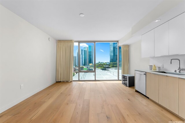 1001 Queen St Unit 1010, Honolulu, HI 96814 - kitchen with dishwasher, modern cabinets, a wall of windows, decorative backsplash, and light wood-style flooring
