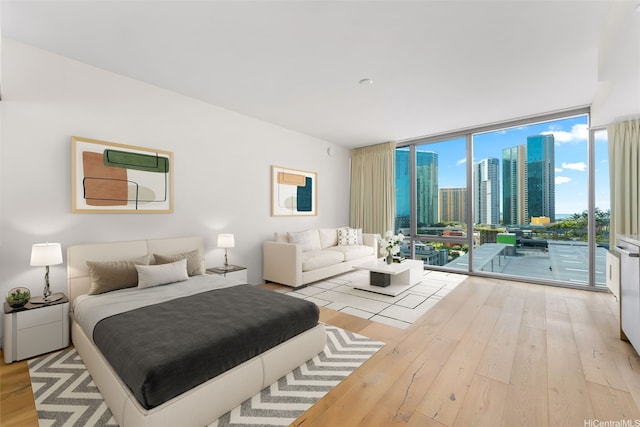 1001 Queen St Unit 1010, Honolulu, HI 96814 - bedroom with expansive windows, access to outside, wood-type flooring, and a view of skyline