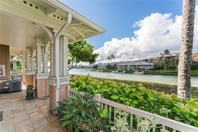 view of patio / terrace featuring a water view and cooling unit
