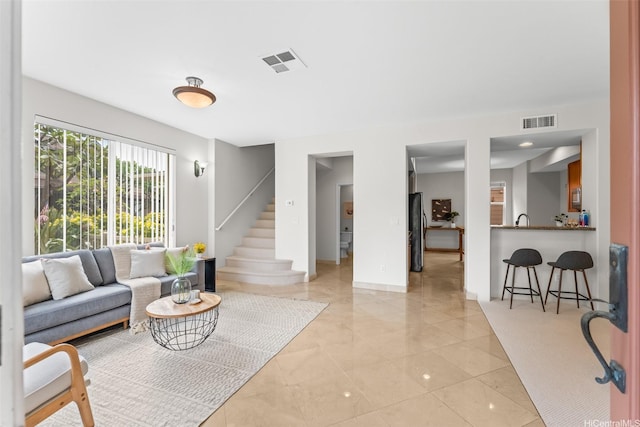 living area with stairway, baseboards, and visible vents