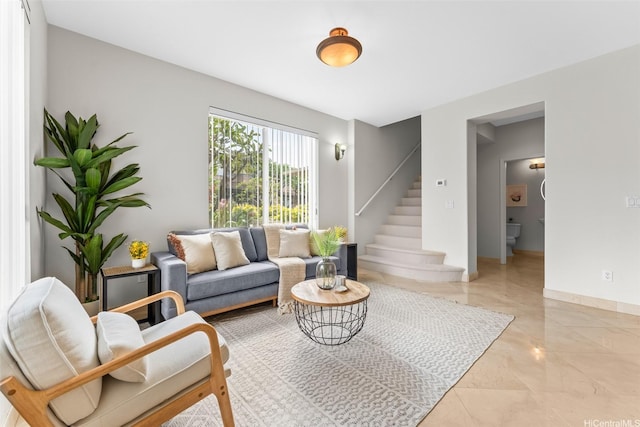 living area with stairway and marble finish floor