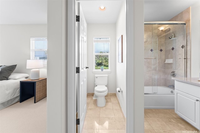 ensuite bathroom with toilet, baseboards, ensuite bathroom, and bath / shower combo with glass door