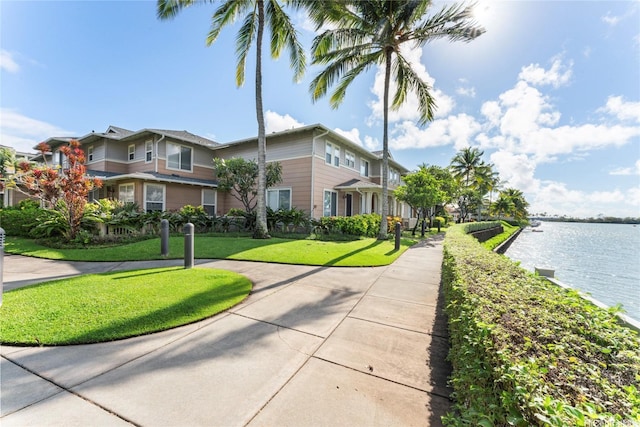 exterior space with a water view and a front lawn