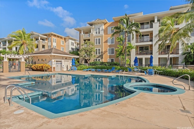 community pool featuring a community hot tub, a patio area, and fence