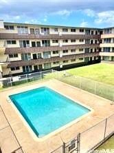 view of pool featuring fence and a yard